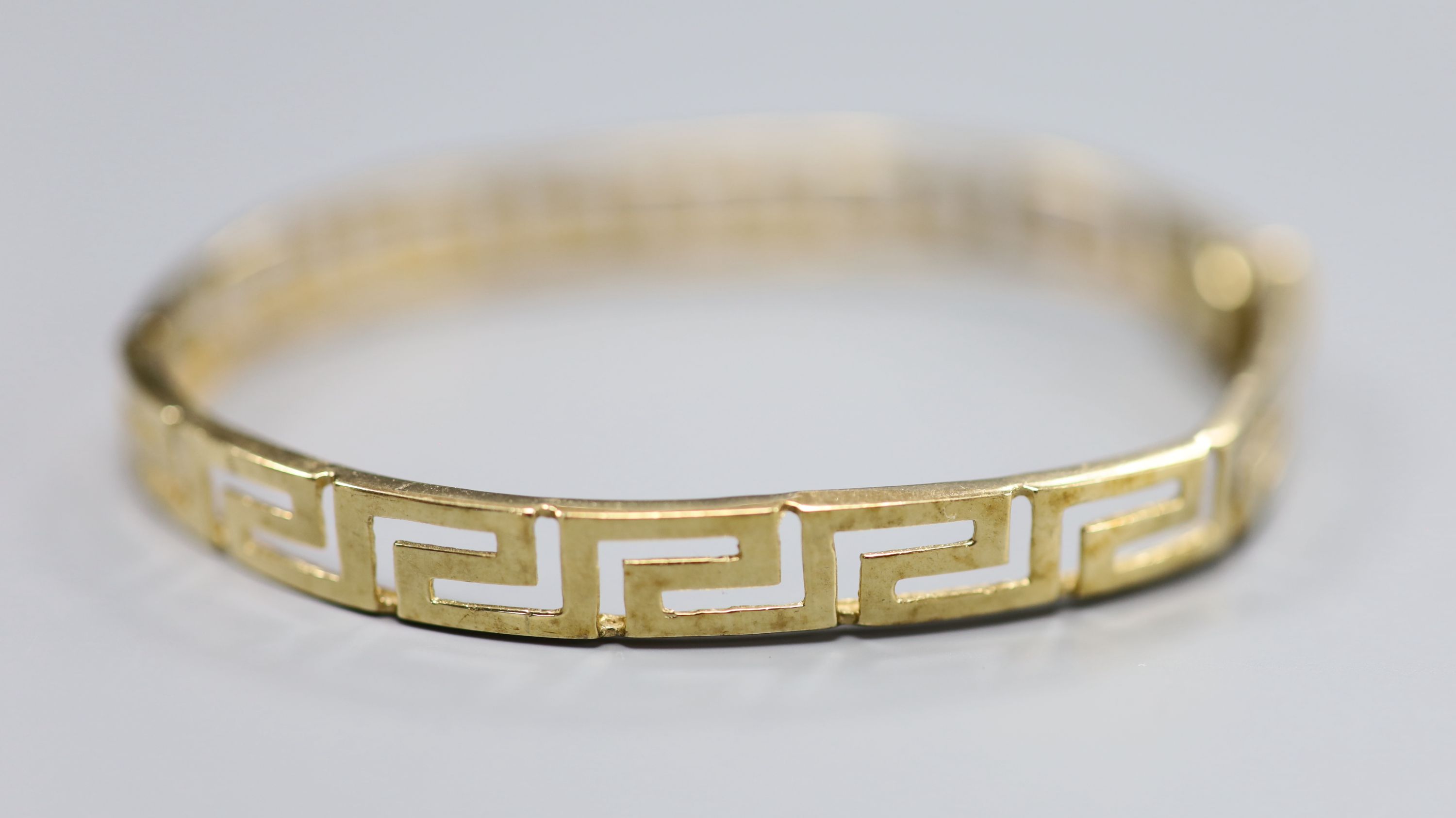 A 9ct gold Greek key design hinged bangle, 10g.